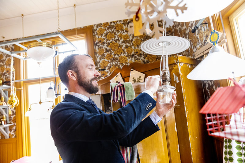 Man i kostym tänder en lampa