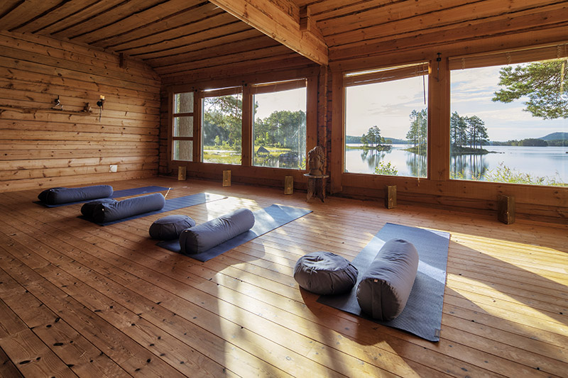 Yogamattor och tillbehör i ett furuklätt rum med utsikt över Nätsjö udde.