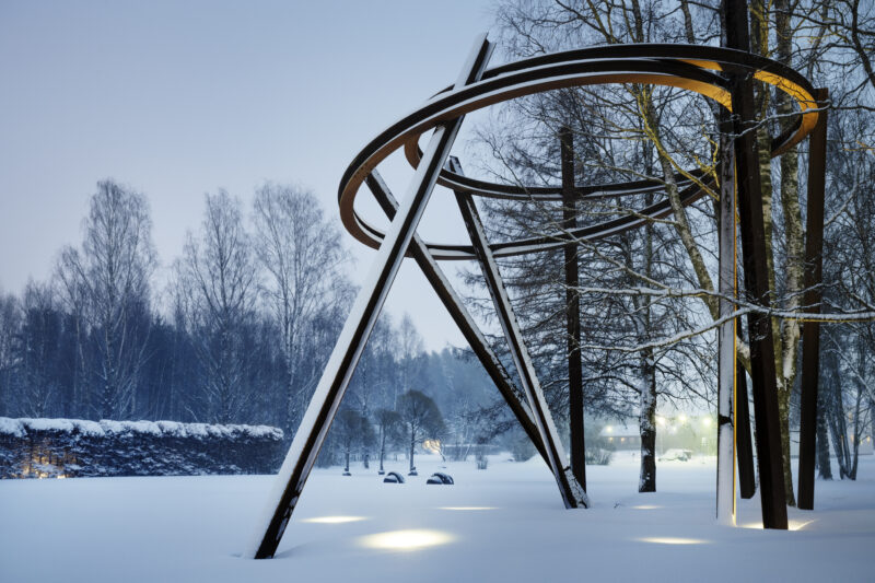 En flera meter hög installation med stålbalkar som bär upp en ring av stål i Umedalens skulpturpark.