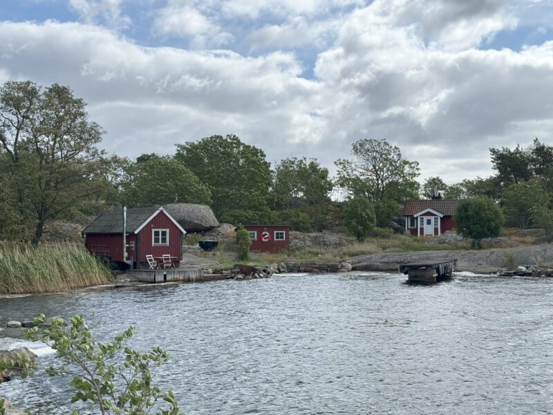 En havsvik med ett litet skärgårdshemman med bastu, torp och brygganläggning i Nämdöfjärdens nationalpark.